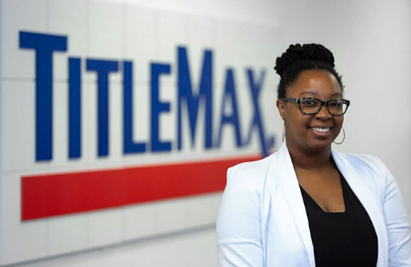 TitleMax employee standing in front of the TitleMax logo.